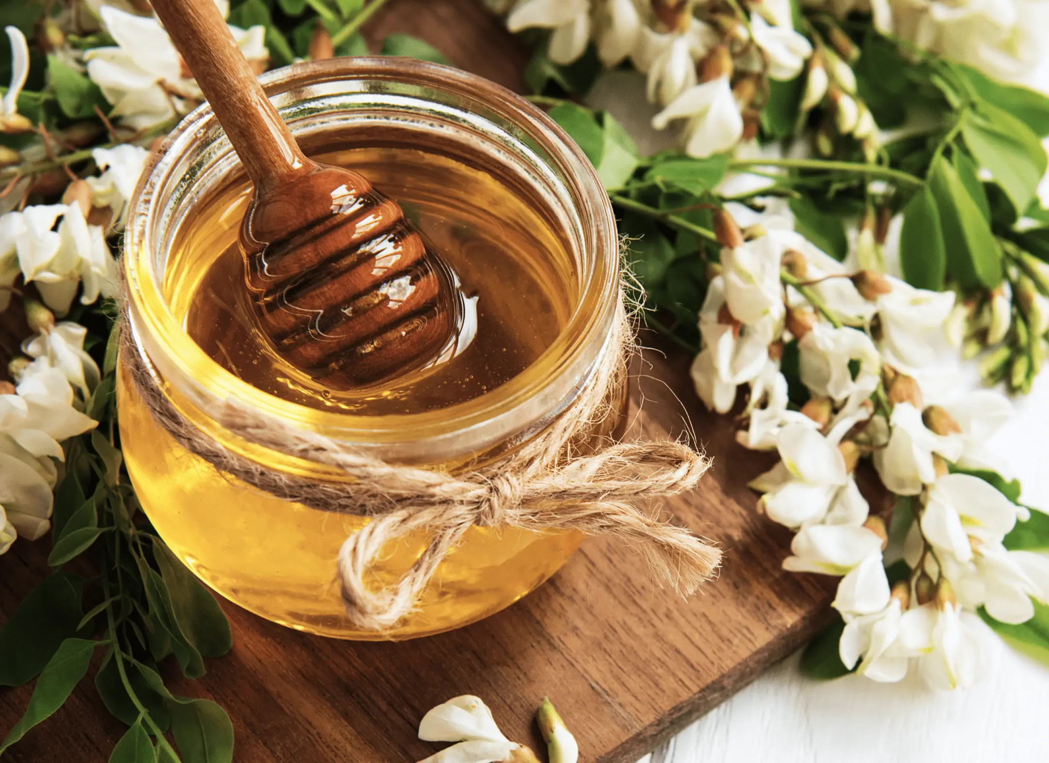 Jar of golden honey with a wooden dipper